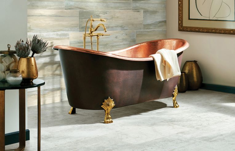 neutral grey ceramic floor tiles in a bright modern bathroom with a copper tub
